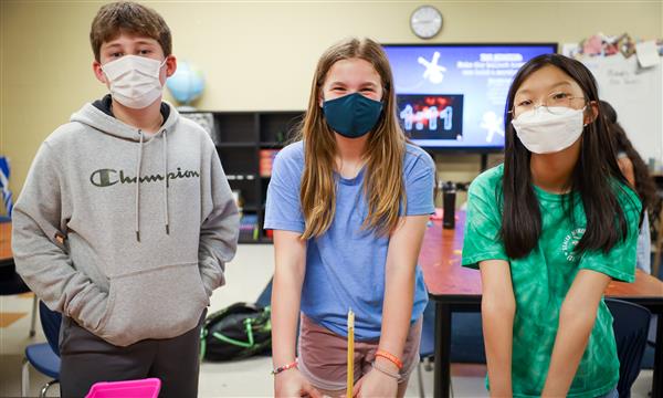 Three students smile for photo